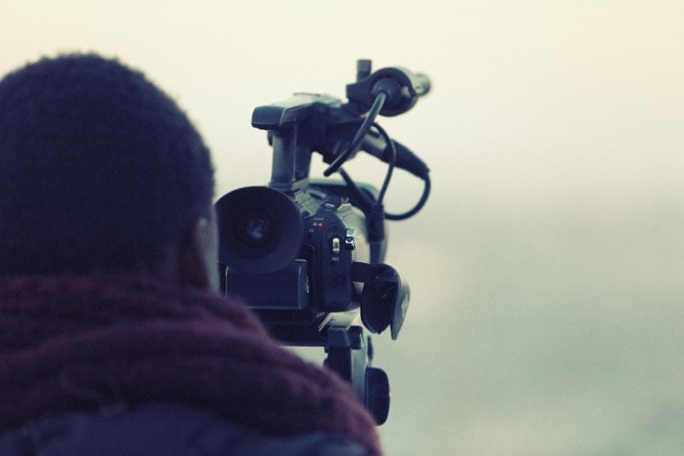 Camera operator filming with a professional video camera